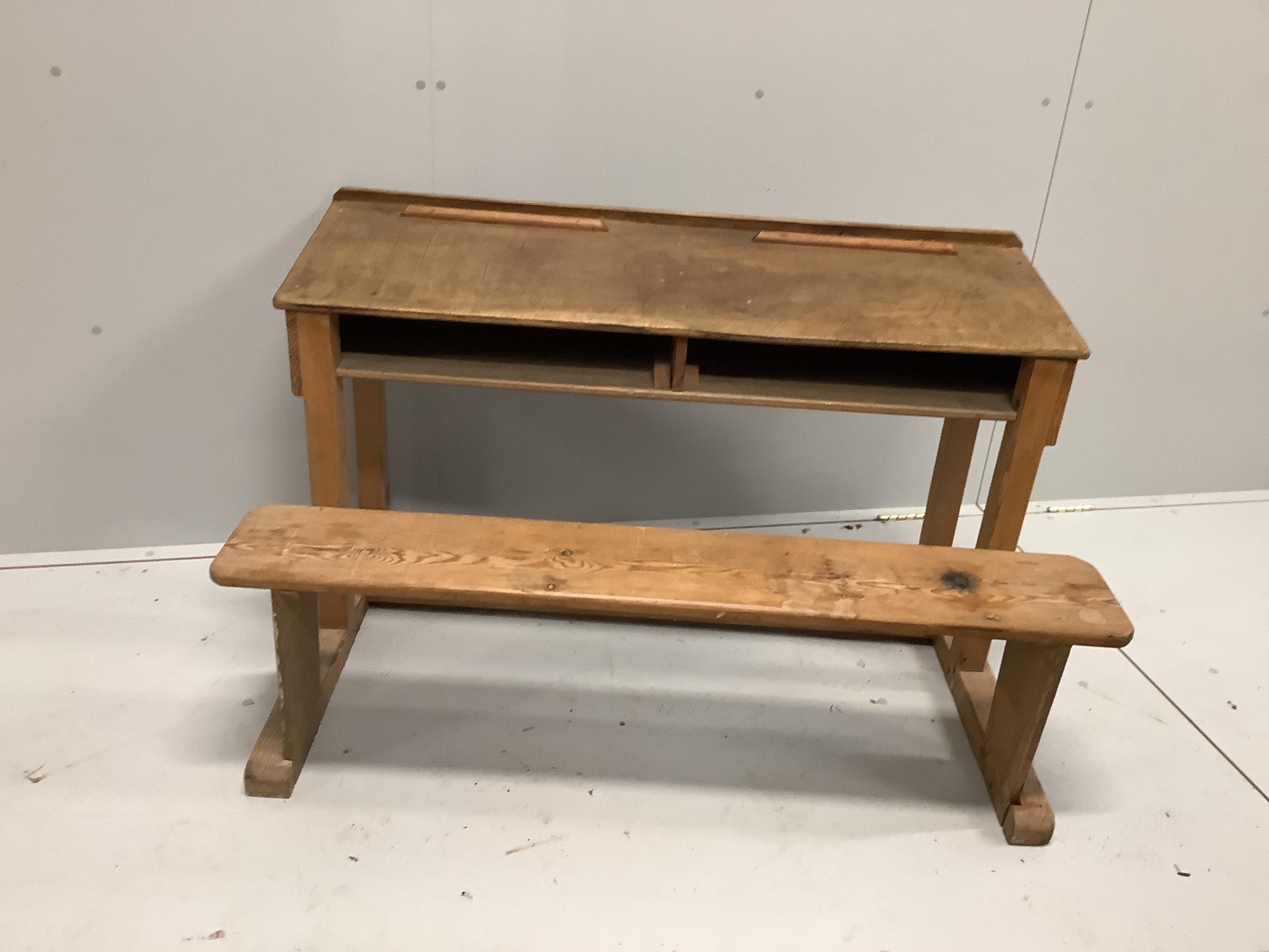 An early 20th century oak and pine child's desk with integral seat, width 120cm, depth 70cm, height 72cm